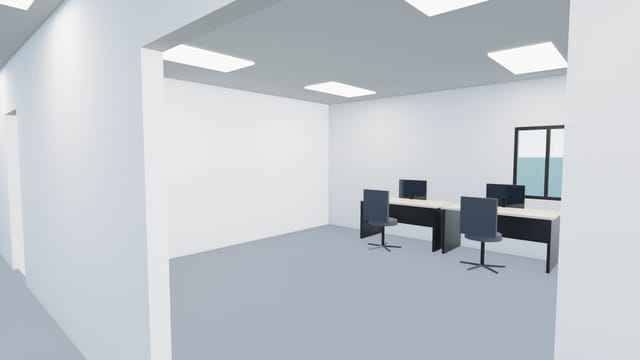 Stepping into an open office with two rows of desks, chairs and monitors under ceiling lights